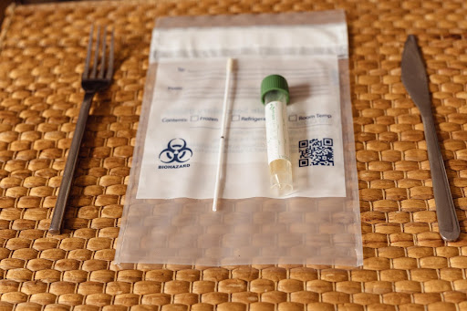 covid-19 swab test on a placemat between a fork and a knife