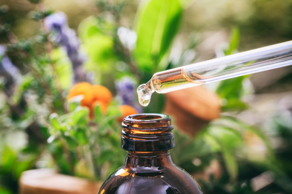 Variety of herbs and dropper with essential oil